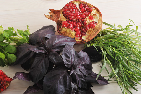 background of pomegranate and Basil leaves and spinach on white wooden table - view from aboveの写真素材