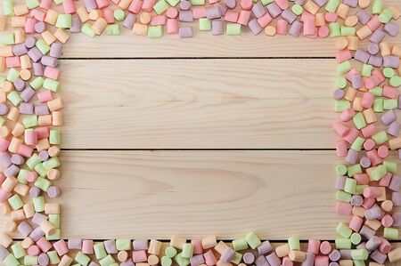 frame of marshmallows with empty place for text on white wooden background - top viewの写真素材