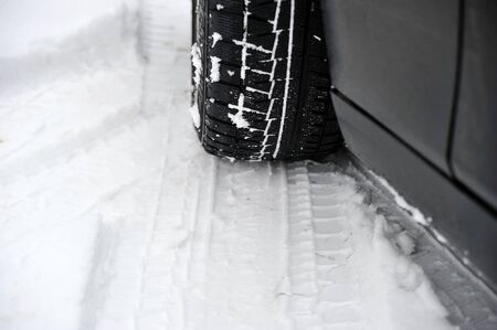 winter tires on the wheel of a car and a sled in the snowの写真素材