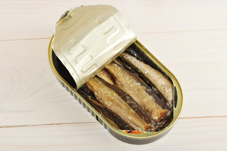 canned sprats in a tin on wooden background - top viewの写真素材