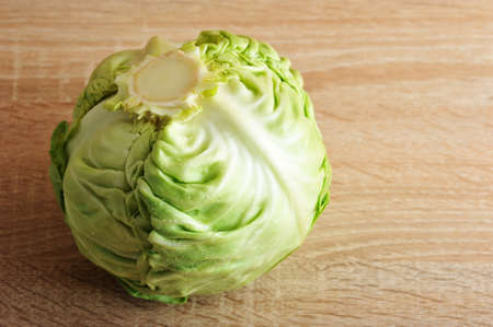whole fresh green head of cabbage on wooden background - close up shotの写真素材