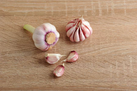 garlic. whole garlic bulb and garlic cloves, unpeeled head of garlic on wooden backgroundの写真素材