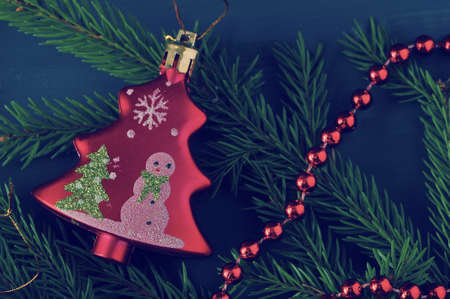 holiday background - Christmas toys and beads with Christmas tree branches on a dark wooden backgroundの写真素材