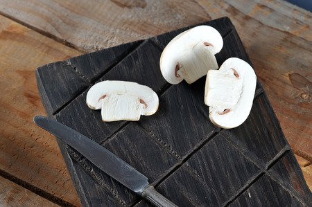 Fresh white mushrooms champignon on rustic wooden background. Copy space.の写真素材