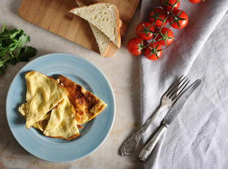 omelette on a plate, parsley, tomatoes, toast and textile napkin with space for text - top view,...