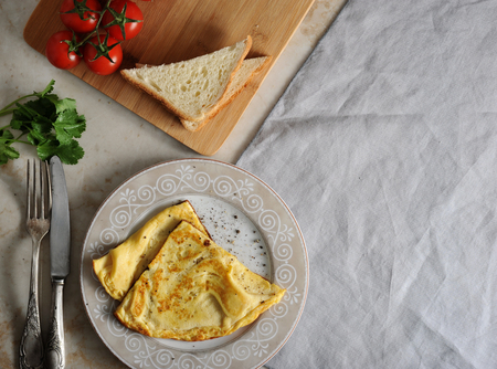 omelette on a plate, parsley, tomatoes, toast and textile napkin with space for text - top view, flat layer, copy space. Healthy, clean eating, vegan, detox, dieting food conceptの写真素材