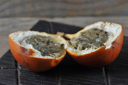 Granadilla or grenadia passionfruit on wooden rustic background の写真素材