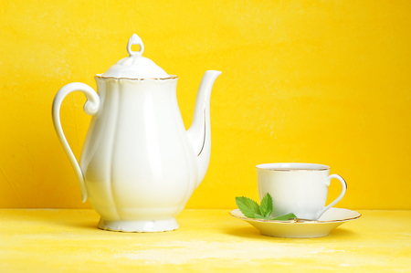Cup of tea kettle on yellow backgroundの写真素材