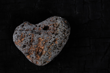 stone in the form of a heart on a black background - abstract background, concept of a heart of stoneの写真素材