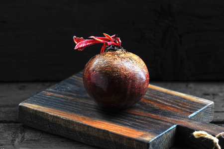 juicy whole beet on a wooden Board on a dark background