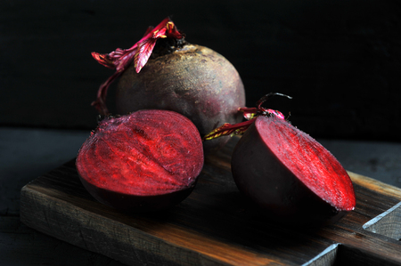 cut into halves of beets on a wooden Board on a dark backgroundの写真素材