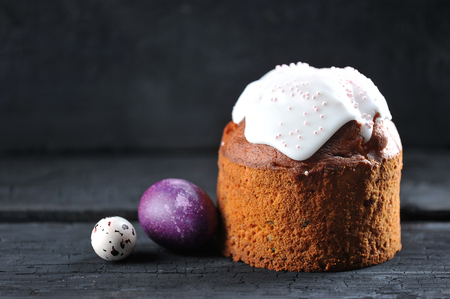Easter background - festive cake and painted eggs on a dark rustic background with space for text