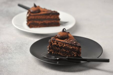piece of chocolate cake on a black plate is an exquisite dessert