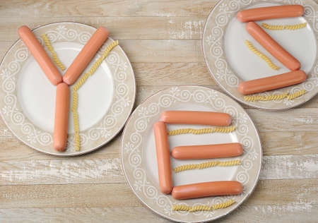 the word Yes - laid out with sausages and pasta on plates - top viewの写真素材