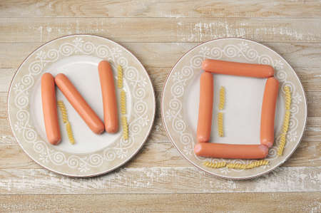 the word No - laid out with sausages and pasta on plates - top viewの写真素材