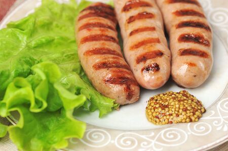 grilled fried sausages on plate with salad leaves and peppers - grilled sausageの写真素材