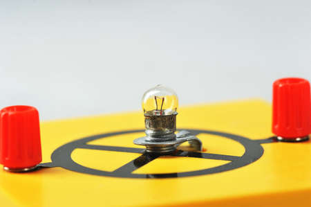 incandescent lamp on a yellow stand - equipment for a physics lesson - glass bulb with the designation of an incandescent lampの写真素材