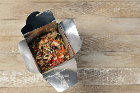 street food chinese noodles in a cardboard box-top view on a wooden backgroundの写真素材