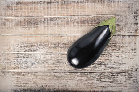 black eggplant on a wooden background - top view - copyspace