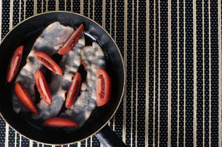 bacon with tomatoes - top view - copy spaceの写真素材