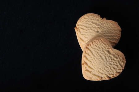 heart-shaped cookies on a black background - top view copyspace