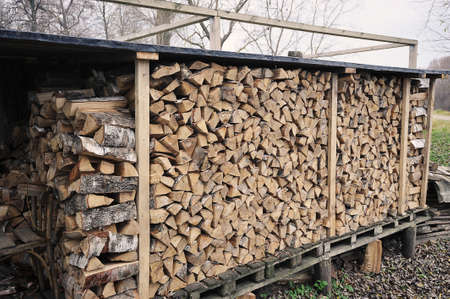 birch firewood stacked in a woodpile - stocks of firewood for the winterの写真素材