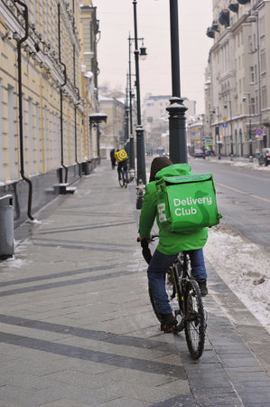 MOSCOW, RUSSIA - JANUARY 29, 2022: a food delivery man on a bicycle in Moscowのeditorial素材