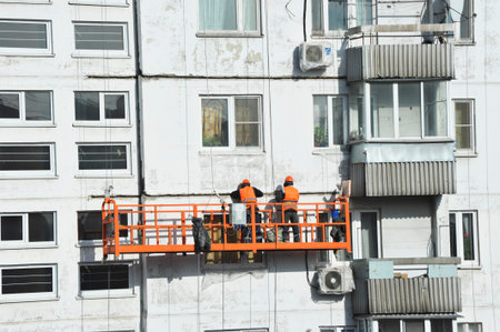 Moscow, Russia - April 12, 2025: workers in overhead elevators perform facade work in Moscowのeditorial素材
