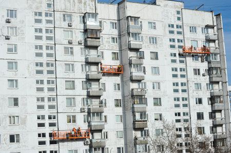 Moscow, Russia - April 12, 2025: workers in overhead elevators perform facade work in Moscowのeditorial素材