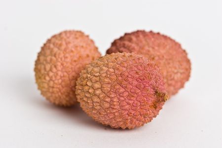 Three Lychee fruits isolated on white. Closeup with selective focusの写真素材