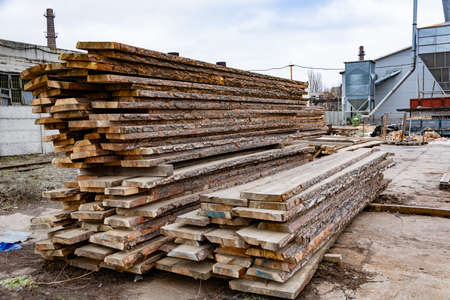 Sawmill A stack of wooden boards in the open air. Sawing, lumber.