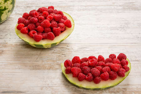 Watermelon, from the berries of ripe red raspberries. Half-length slice of watermelon with raspberries Copy spaceの写真素材