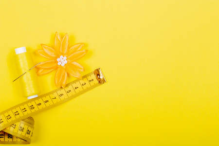 A set of tools and accessories for tailoring on a yellow background. Flat Lay, top view, Copy space,...