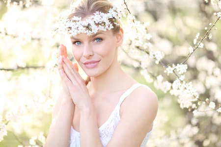 Beauty romantic woman portrait in blooming treesの写真素材