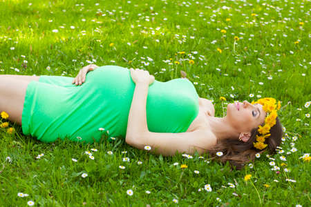 Beautiful and smiling pregnant woman relaxing in the summer parkの写真素材