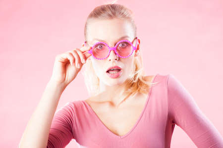 Shocked woman in pink glasses! Wow! Special prices, only today.の写真素材