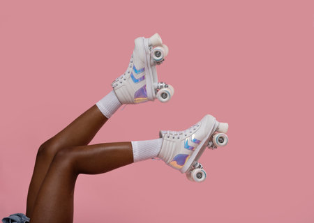 Cropped image of female legs with roller skates against pink backgroundの写真素材