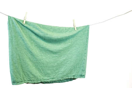 Green t-shirt hanging on a clothesline. White background.