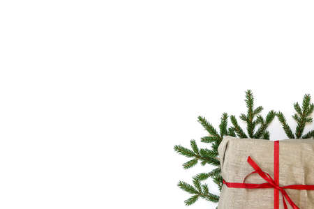 Fir branch / twig and burlap canvas christmas gift box on white background. Christmas border with empty blank copy space for text.の写真素材