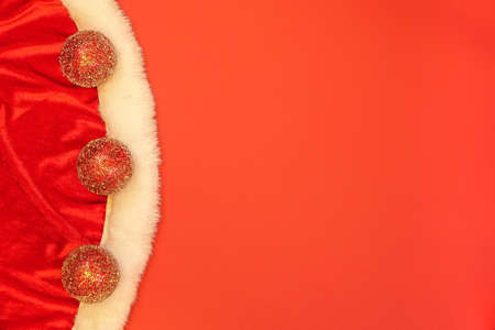 Close-up of Santa's clothes and christmas decoration glitter balls on red background. Empty blank copy space for text.の写真素材