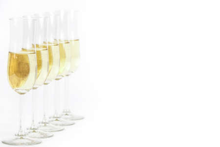 Glasses of champagne lined up. For new years eve celebration and special moments. Empty copy space for text on simple white background.の写真素材