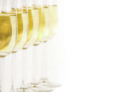 Glasses of champagne lined up. For new years eve celebration and special moments. Empty copy space for text on simple white background.の写真素材