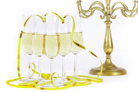 Glasses of champagne lined up and party streamers. For new years eve celebration and special moments. Candelabra in background.の写真素材