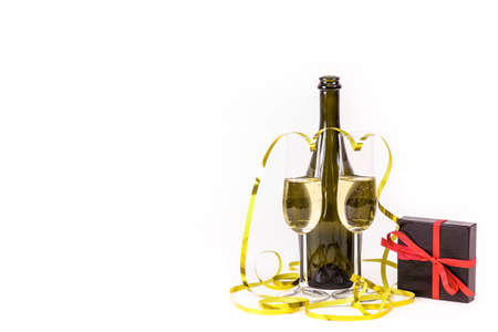 Glasses of champagne, gift box and party streamers. For new years eve celebration, valentine's day and special moments. Empty copy space for text on simple white background.の写真素材