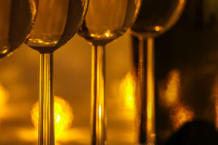 Cozy evening with glasses of white wine. For celebrations and special moments. Warm decoration light in background.の写真素材