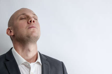 Businessman in suit takes a deep breath and preparing for something big. White background with copy space for text.の写真素材
