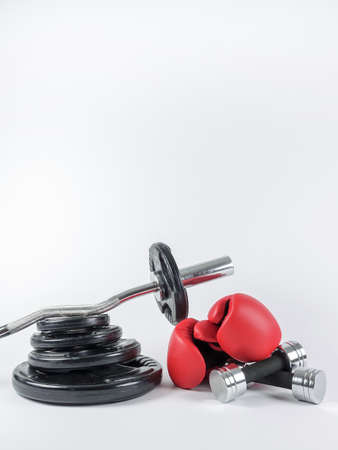 Gym gears. Weight plates, curl bar, boxing gloves and two dumbbells in a heap. Place for own text / copy space.の写真素材