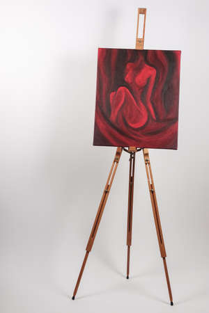 Expressive beautiful acrylic painting with a nude woman, painted in red and black. Original artwork on canvas. On studio / floor easel.の写真素材