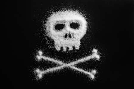 Sugar in the form of a skull and bones. Concept that sugar and sweets are dangerous or cocaine and drugs are fatal deadly and dangerous.の写真素材