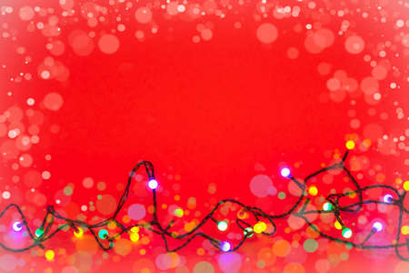 Christmas lights over red background. Colorful border with empty copy space for text.の写真素材